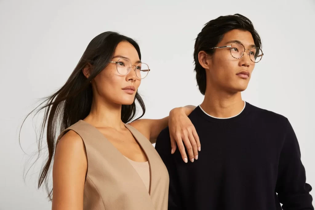 A woman and a man wearing Cole Haan eyeglasses.
